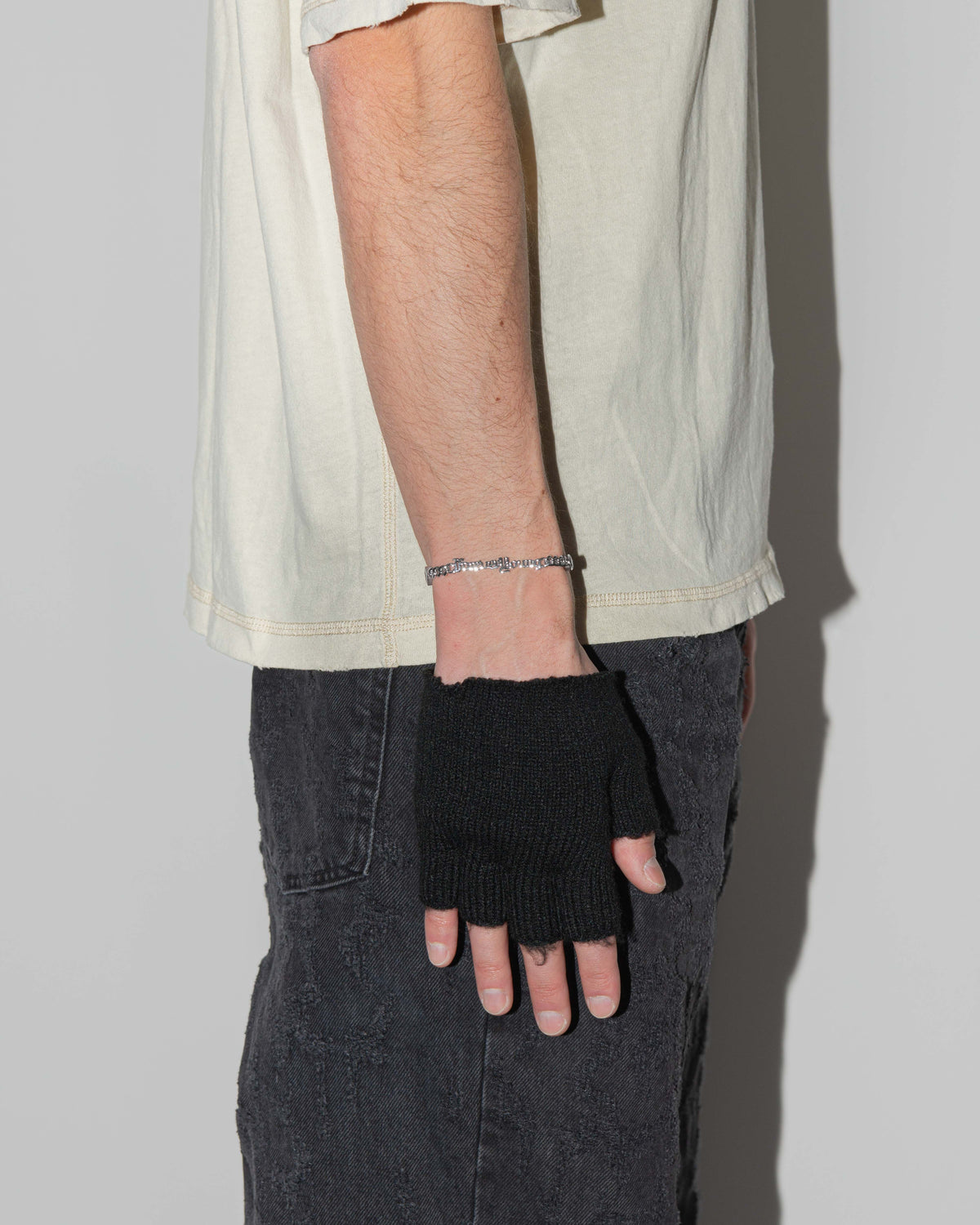 man wearing forever young cuban chain bracelet with 18kt white gold coating, mixed shape bezel stones in diamond white, burna blue, green, chocolate and "Forever Young" central metal tag