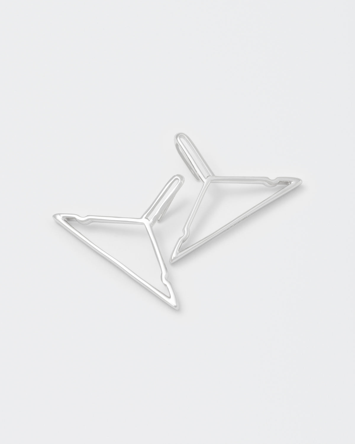 detail of hanger shaped earrings with 18kt white gold coating, silver 925 pin and engraved logo.